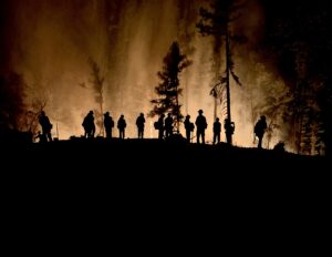 Firefighter silhouettes with the fire back lighting them 