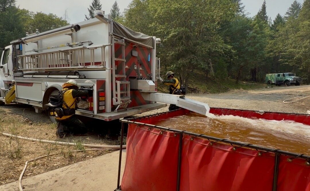 Despite gusty winds, firefighters continue to establish line across East Evans Creek Fire, all spot fires